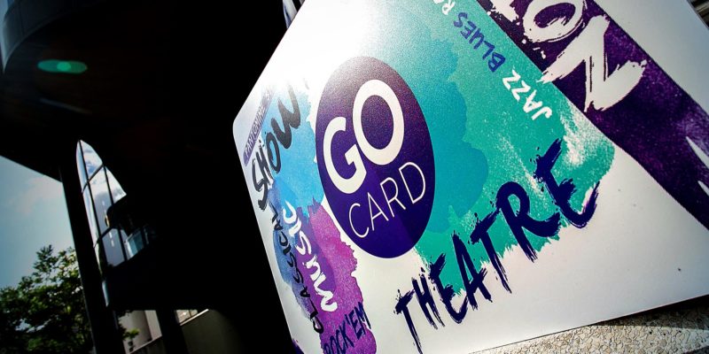 A Go Card (with its signature purple and turquoise paint streaks and circular logo) sits just outside the Royal Concert Hall's doors.